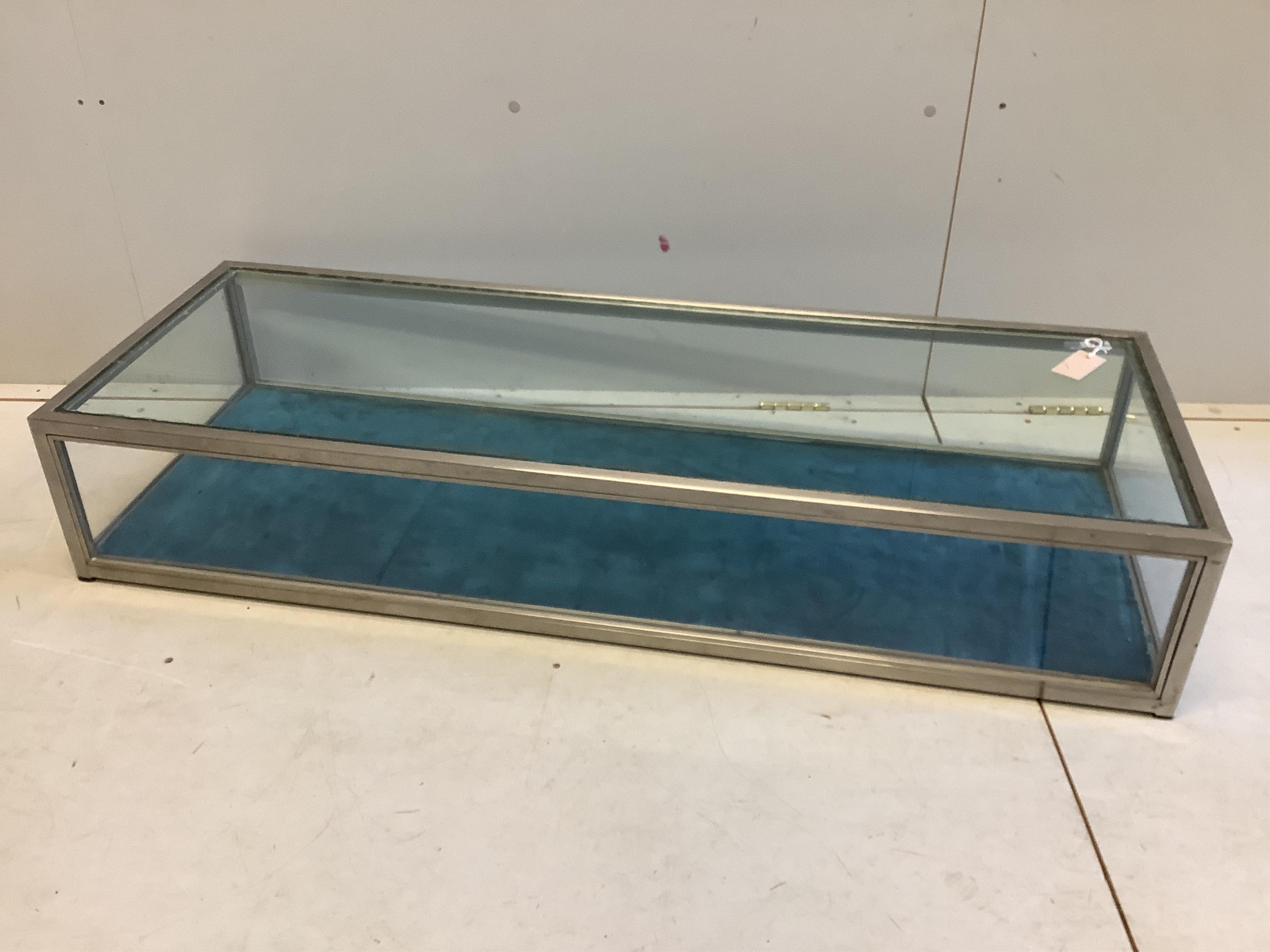 A modern brushed steel and glass counter top jewellery display case, width 128cm, depth 47cm, height 23cm. Condition - poor, glass top damaged to one corner, lacks sliding doors.